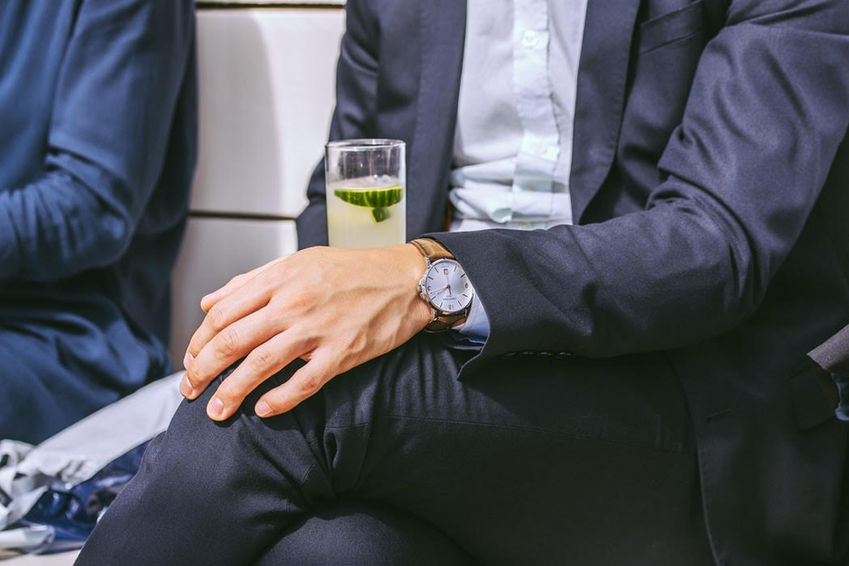seated business man holding a cocktail at networking event