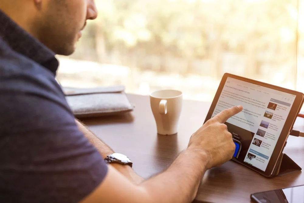 casual man reading the news on tablet