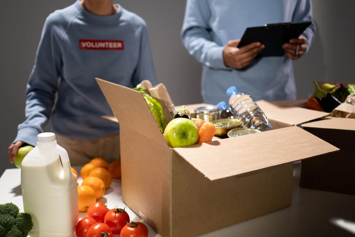 food pantry volunteers organizing produce in cardboard boxes
